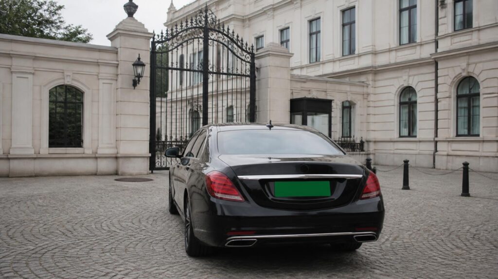 Berline officielle avec une plaque verte vierge dans la cour d’un bâtiment diplomatique
