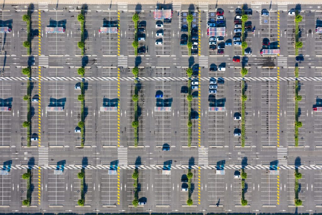 Vue aérienne d’un parking de centre commercial en France avec des voitures garées